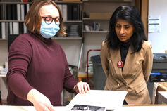 Chancellor Latha Ramchand studies a book with a female.
